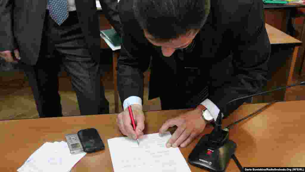 Голова лічильної комісії Артур Савін підписує документ, що рішення про відставку мера Черкас ухвалене