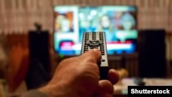 GENERIC – Watching TV and using remote control