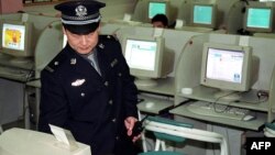 Китайский полицейский проверяет работу интернет-кафе. Пекин,17 июня 2002 года. Иллюстративное фото. 