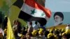 File photo - Lebanese Hezbollah supporters wave a Syrian flag under a huge portrait of Iran's supreme leader, Ayatollah Ali Khamenei, during a rally in the southern town of Bint Jbeil on May 25, 2012.