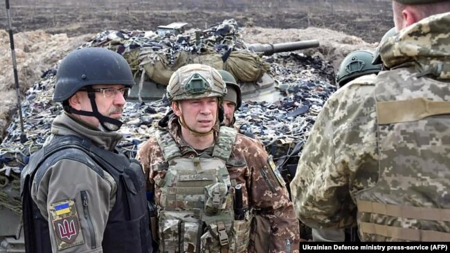 Defense Minister Oleksiy Reznikov (left) talks to troops on an unspecified section of the front line in Ukraine on March 24.