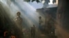 A girl stands outside her house as a health worker fumigates a residential area to prevent the spread of mosquito-borne diseases in Ahmedabad, India. (Reuters/Amit Dave)