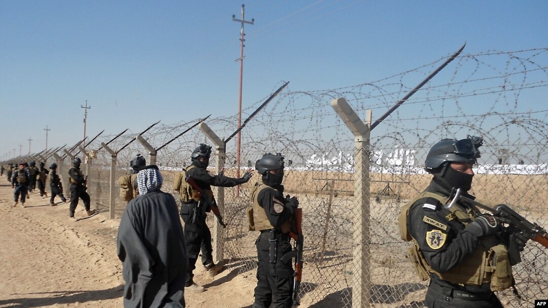 Iraqi SWAT forces stand guard outside Camp Ashraf during a protest on December 9 by Iraqis calling for the camp to be closed and for its residents to be deported.