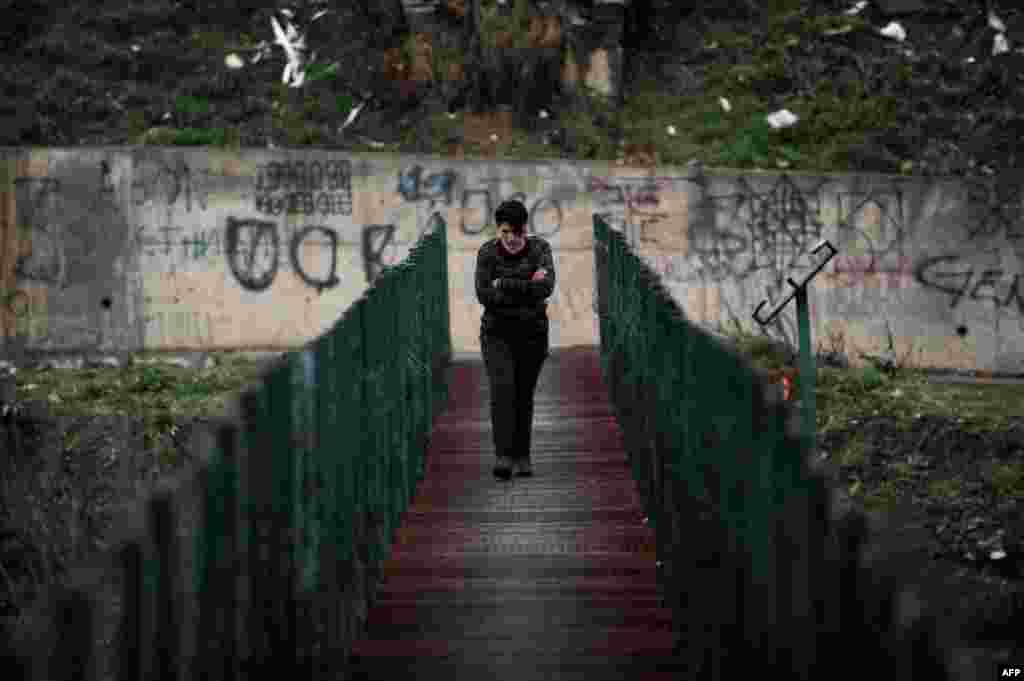 A woman walks on a footbridge in Mitrovica, Kosovo. (AFP/Armend Nimani)