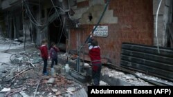 Copii la o pompă de apă din Arbin, Ghouta de est, Siria, 25 februarrie 2018