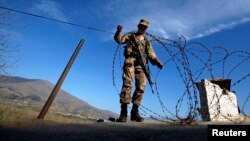 A soldier creates a barrier using barbed wire at a security checkpoint in the Swat valley region. (file photo)
