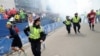 Police and runners react after two explosions at the Boston Marathon.