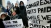 U.S. -- Government workers and their supporters hold signs during a protest in Boston, Friday, Jan.11, 2019