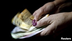 Azerbaijan -- A woman holds manat banknotes, national currency of Azerbaijan, in this photo illustration taken on January 18, 2016