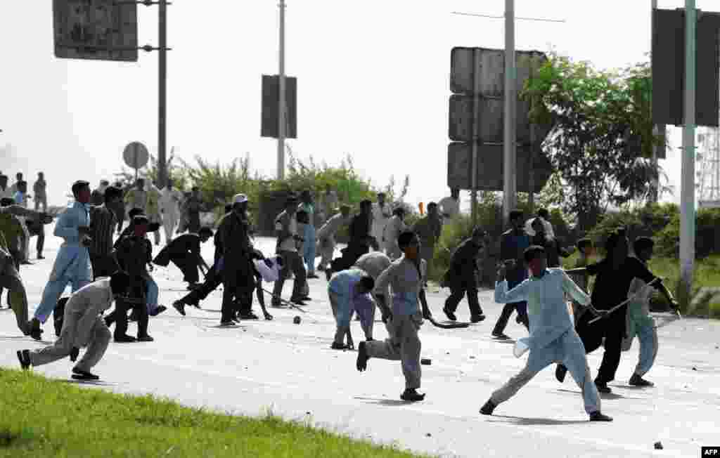 Pakistani demonstrators throw stones at riot police.