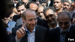 Mohammad Baqer Qalibaf shows his ink painted finger after his vote during the presidential election in Iran.