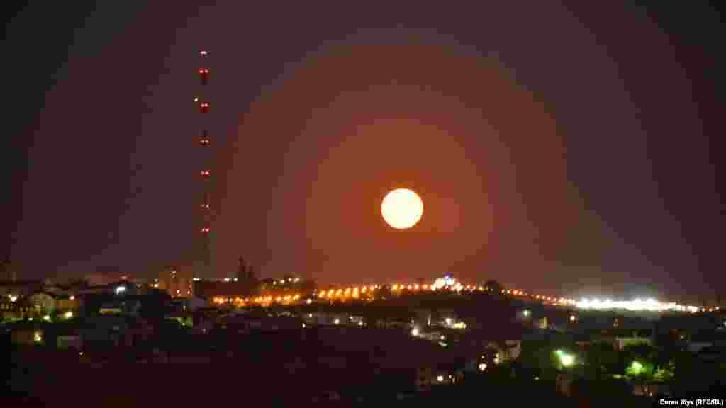 Краєвид з оглядового майданчика на площі Ушакова в Севастополі. Місяць висить над горою Воронцова, видно телевізійну вежу та арку, встановлену на честь 200-річчя міста