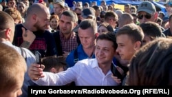 Ukrainian President Volodomyr Zelenskiy takes a selfie with a well-wisher while on a visit to the port city of Mariupol on June 15.