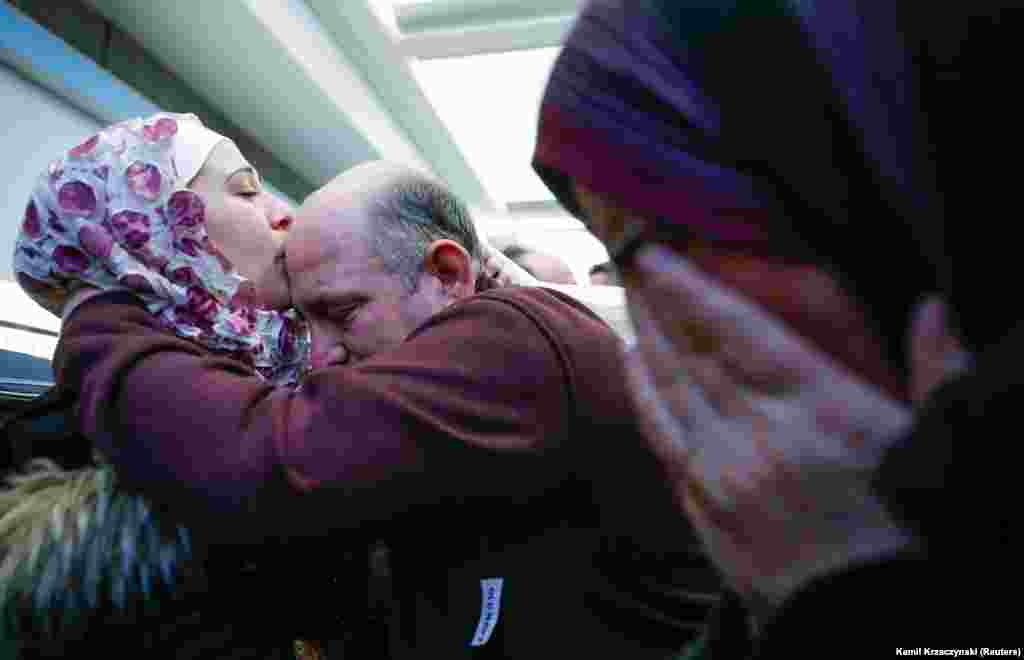 Біженка із Сирії Бараа Хай Халаф (зліва) цілує батька Халеда, в той час, як її мама (праворуч) плаче після прибуття до міжнародного аеропорту Чикаго, штат Іллінойс, 7 лютого, 2017 року. Їм довго не вдавалось приїхати через обмеження на в&#39;їзд до США громадян семи мусульманських країн, включаючи Сирію. (Reuters / Камиль Крзацзинський)&nbsp;