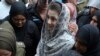 Police officers escort Maryam Nawaz when she appears in an accountability court in Lahore on August 9.