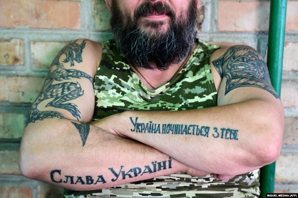 Një ushtar ukrainas tregon krahët e tij me tatuazhe, ku shkruhet "Lavdi Ukrainës" (majtas) dhe "Ukraina fillon me ty" (djathtas), në rajonin e Donjeckut.