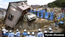Рятувальники шукають зниклих людей у зруйнованому будинку в місті Кумано, префектура Хіросіма, 9 липня 2018 року