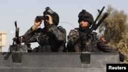 عنصران من قوة أمنية عراقية في نقطة تفتيش ببغداد.