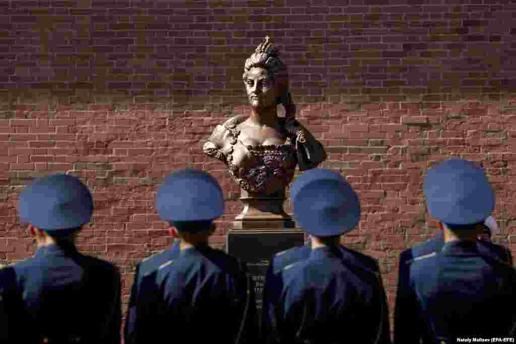 Soldiers stand in front of a depiction of Catherine the Great during the opening of a gallery of busts of Russian figures in St. Petersburg on August 24. (epa-EFE/Anatoly Maltsev)