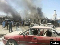 Villagers gather at the site of a truck bomb attack in Orgun on July 15, 2014.