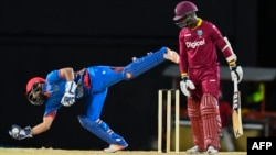 Shafiqullah Shafaq (L) of Afghanistan stops West Indies from scoring during the a T20 match in 2017.