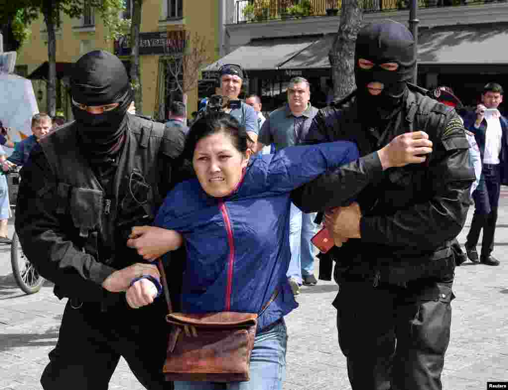 Задержание еще одной участницы акции протеста в Алматы, собравшей несколько десятков человек. 10 мая 2018 года.