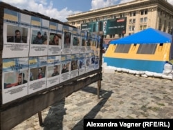 Рядом с палаткой волонтеров установлены фотографии находящихся в московском СИЗО украинских моряков