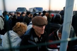 People wait to get through a checkpoint linking Ukrainian government-controlled territory and separatist regions after Kyiv decided to block entry to residents registered in separatist-held areas to stop the coronavirus on March 13.