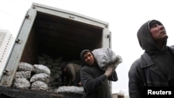 Russia -- Migrant workers work unload potato sacks at a vegetable market on the outskirts of Moscow, November 11 2011