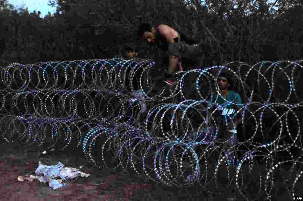 Беженцы из нескольких стран пытаются преодолеть металлический забор на границе между Сербией и Венгрией