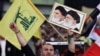 A Hezbollah supporter chants slogans, as he holds a picture of the late Iran revolutionary founder Ayatollah Khomeini, left, and Iran's Supreme Leader Ayatollah Ali Khamenei, right. File photo