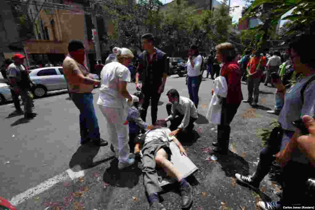 MEXICO -- People help an injured man react after an earthquake hit Mexico City, Mexico September 19, 2017.