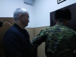 Кубанычбека Кулматова выводят из зала суда.