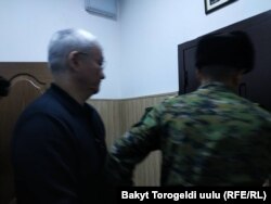 Кубанычбека Кулматова выводят из зала суда.
