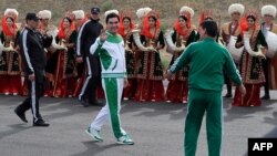 Turkmen President Gurbanguly Berdymukhammedov (center) waves to the media during the starting ceremony of a 500-day nationwide horse race at the historical site of Nisa just outside Ashgabat on May 5, 2016, in preparation for the 2017 Asian Indoor and Martial Arts Games.