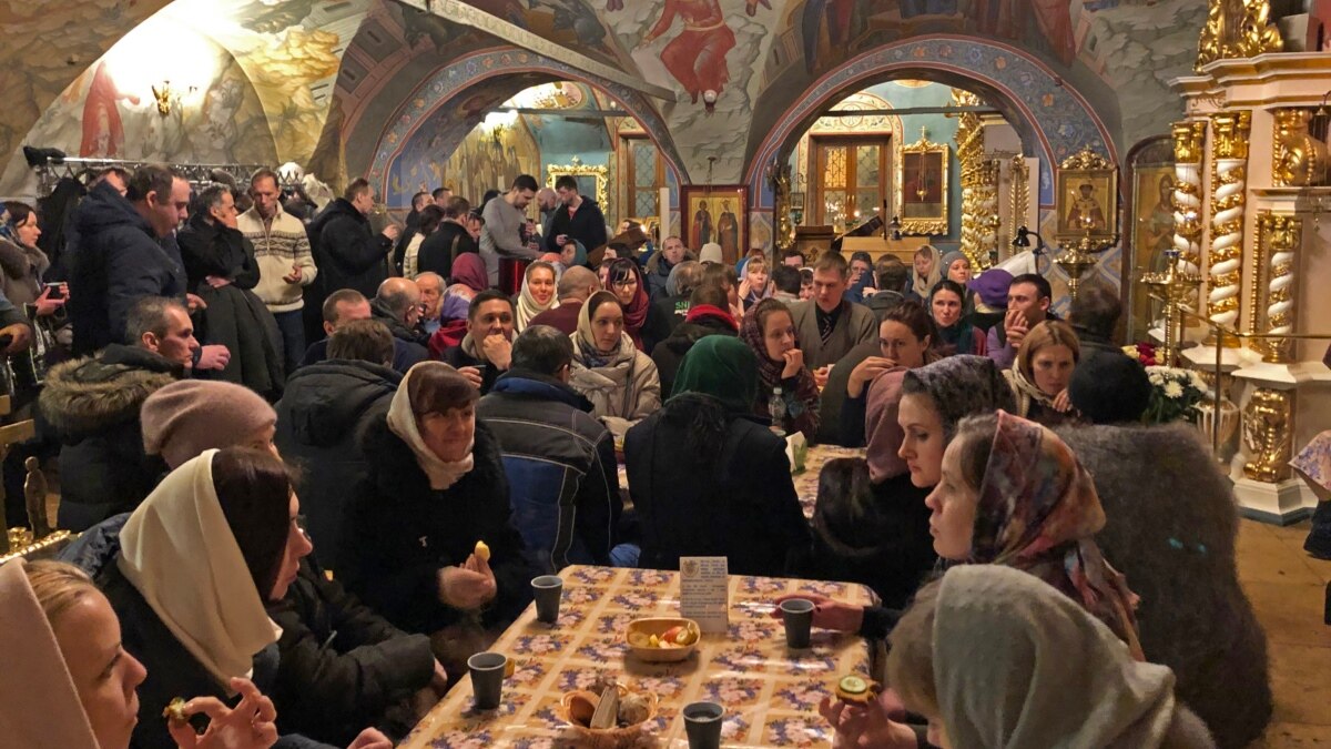 Russian woman in winter clothes against Orthodox monastery