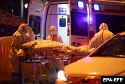 Спецотряд медиков забирает очередного заболевшего в городе Ухань. 23 января 2020 года
