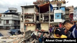 Жители одного из разрушенных кварталов Катманду ищут выживших под завалами. 25 апреля 2015 года.