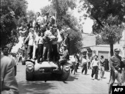 İran ordusunun zabitləri və monarxiya tərəfdarları şahın ölkəyə qayıdışını alqışlayırlar. 27 avqust 1953.