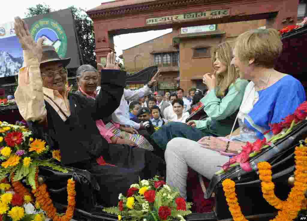 Kancha Sherpa, a member of the 1953 Mount Everest expedition, and Amelia Rose Hillary (second from right), granddaughter of mountaineer Sir Edmund Hillary, wave during a procession for Everest summitteers in Kathmandu.