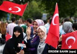 شماری از زنان ترک با پرچم‌های ترکیه در دست، در تجمعی در سالگرد کودتای ۲۰۱۶