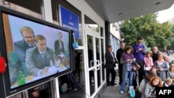 Журналісти дивляться телевізійну трансляцію аукціону з продажу Одеського Припортового заводу біля будівлі Фонду державного майна де відбувався аукціон. Київ, 29 вересня 2009 року.