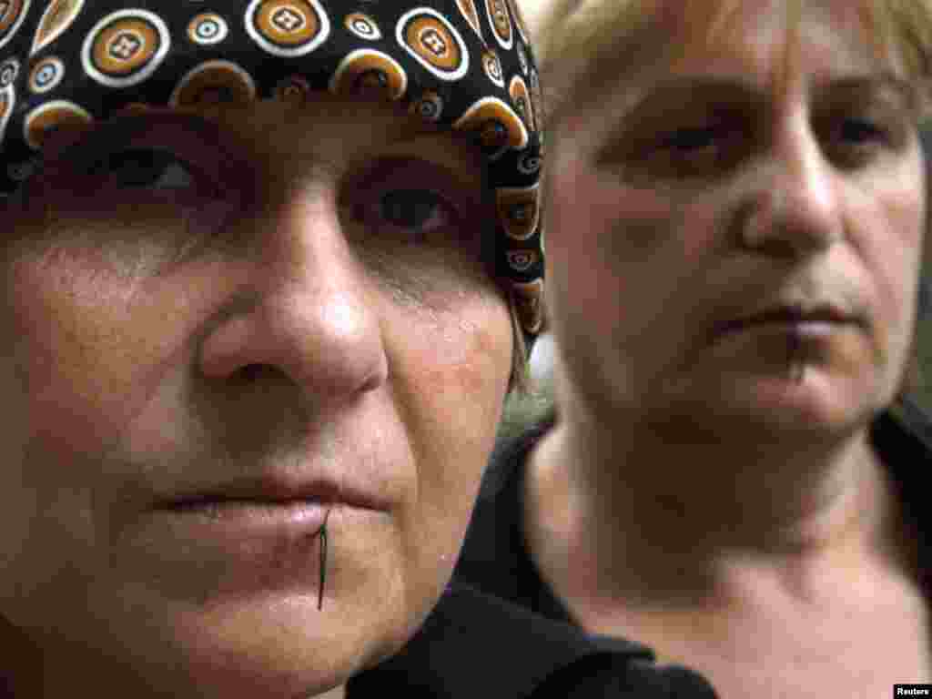 Two displaced Georgian women from Abkhazia are seen with their lips sewn together during a hunger strike in Tbilisi on August 25. Dozens of displaced protested against a government decision to evict them from the houses they live in now. Photo by David Mdzinarishvili for Reuters