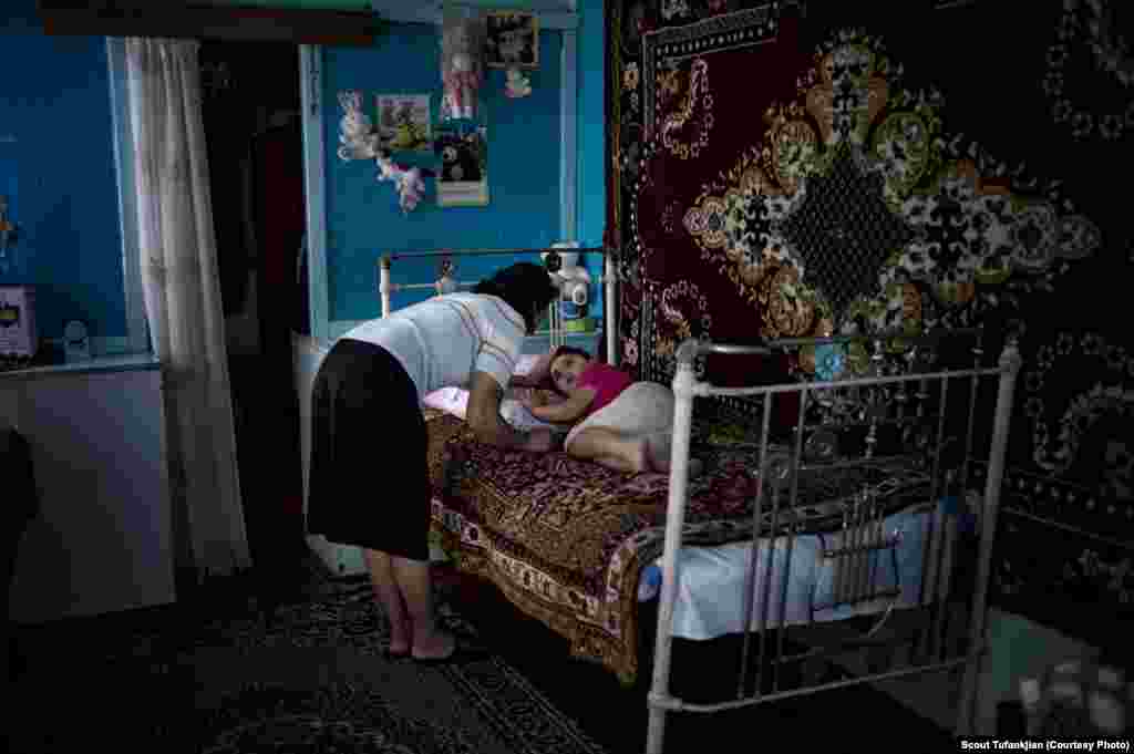 Anoush Gasparyan watches her five year old sleeping daughter Anahid in their home in the village of Myasnikyan. The family, which is struggling after a series of accidents and health issues including snake bite and lightning strikes, receives help from the diaspora-based Children of Armenia Fund (COAF). COAF was founded by Istanbul-born, American-based Armenian Dr. Garo Armen, who was struck by the depths of poverty in the Aramir region of Armenia and resolved to do something about it. The organization, which is largely supported by Diasporan Armenians, mostly funds schools, but also assists in providing a more comprehensive social care to the families of the village children.