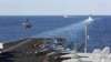 The aircraft carrier USS Abraham Lincoln transits the Strait of Hormuz as an MH-60S Sea Hawk helicopter lifts off from the flight deck, November 19, 2019