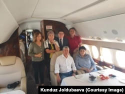 Almazbek (seat at left) and his entourage aboard a private jet to Moscow on July 24.