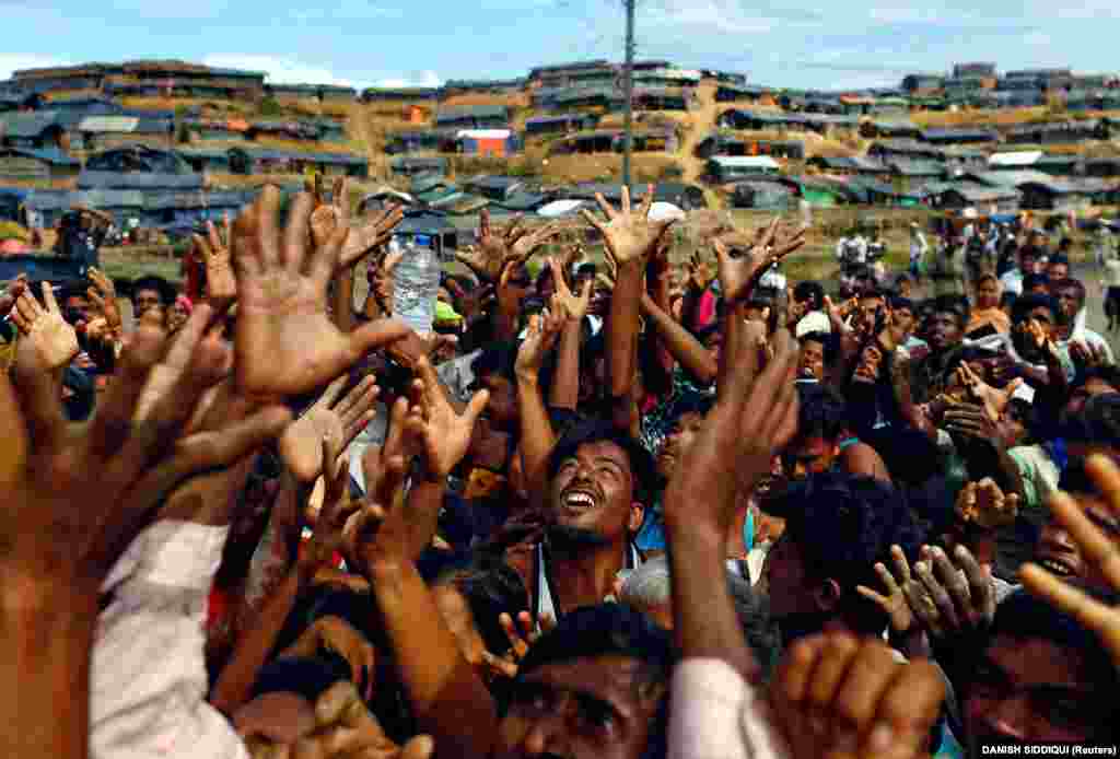Rohingya refugees from Burma stretch their hands to receive aid distributed by local organizations at the Balukhali makeshift refugee camp in Cox's Bazaar, Bangladesh. (Reuters/Danish Siddiqui)