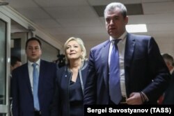 France's National Front leader Marine Le Pen (center) is welcomed by Leonid Slutsky (right), chairman of the Russian State Duma Committee for International Affairs, in Moscow on March 24.
