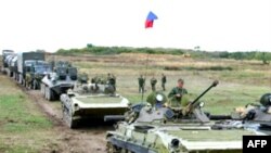 Russian soldiers sit on armored vehicles prior to their departure from a checkpoint in Kventakosa.