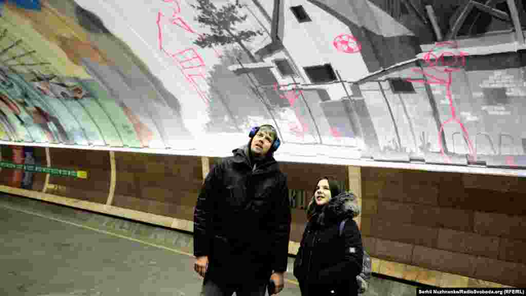 Commuters checking out the station&#39;s new paint job on December 19. The theme of the murals is the &quot;national unity of Ukraine,&quot; according to Geo Leros, the curator of the project. Many of the murals reference the ongoing war in the country&#39;s eastern Donbas region.&nbsp;&nbsp;